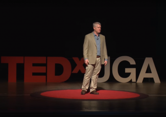 Keith Campbell stands on the UGA Tedx Stage and speaks about his research