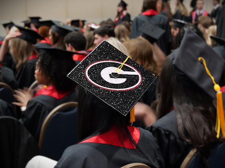 Photo of the back of a student's graduation cap. It has the UGA G on it in rhinestones.