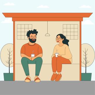 Two people chatting at a bus stop.